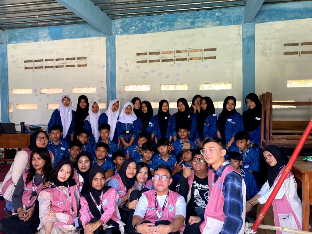 Foto bersama mahasiswa UIC berompi merah muda dan siswa Sekolah Alam Pangrango berseragam batik biru.