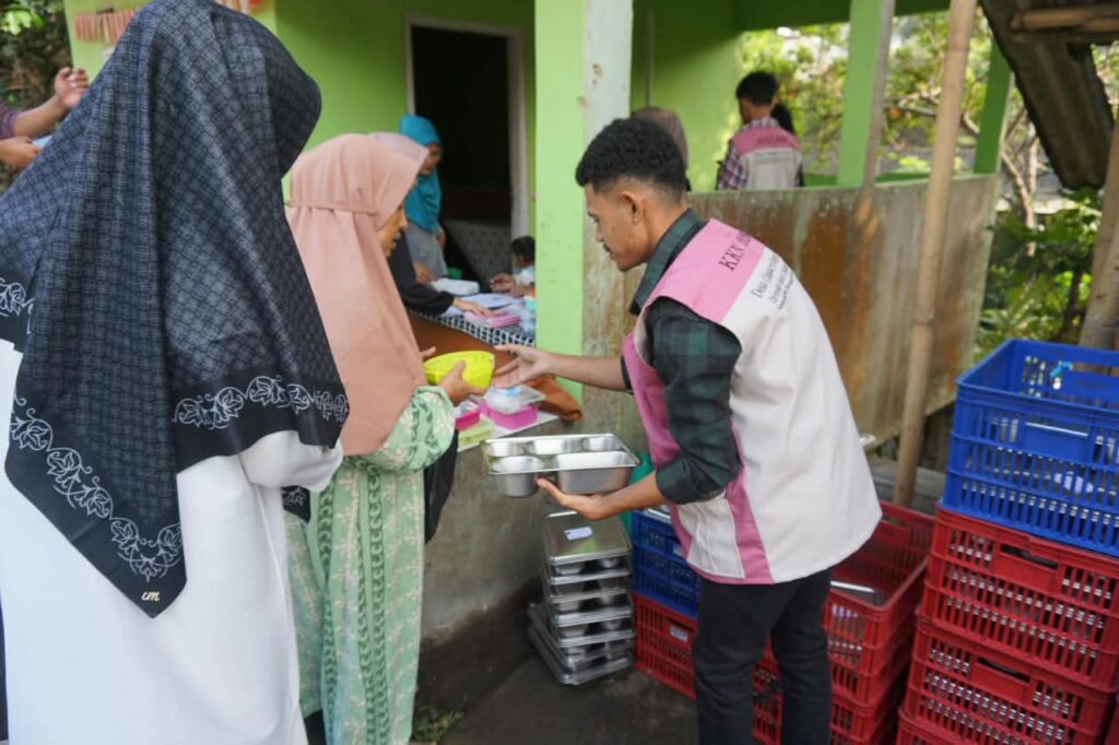 Mahasiswa KKN UIC menyerahkan nampan makanan bergizi dan semangka kepada warga di Posyandu Desa Cinagara.