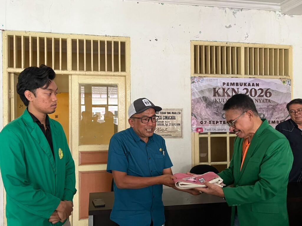 Penyerahan simbolis rompi dan ID Card KKN Universitas Ibnu Chaldun Jakarta oleh Sekdes Desa Cinagara, Pak Uan, bersama Dekan Dahri Zainal.